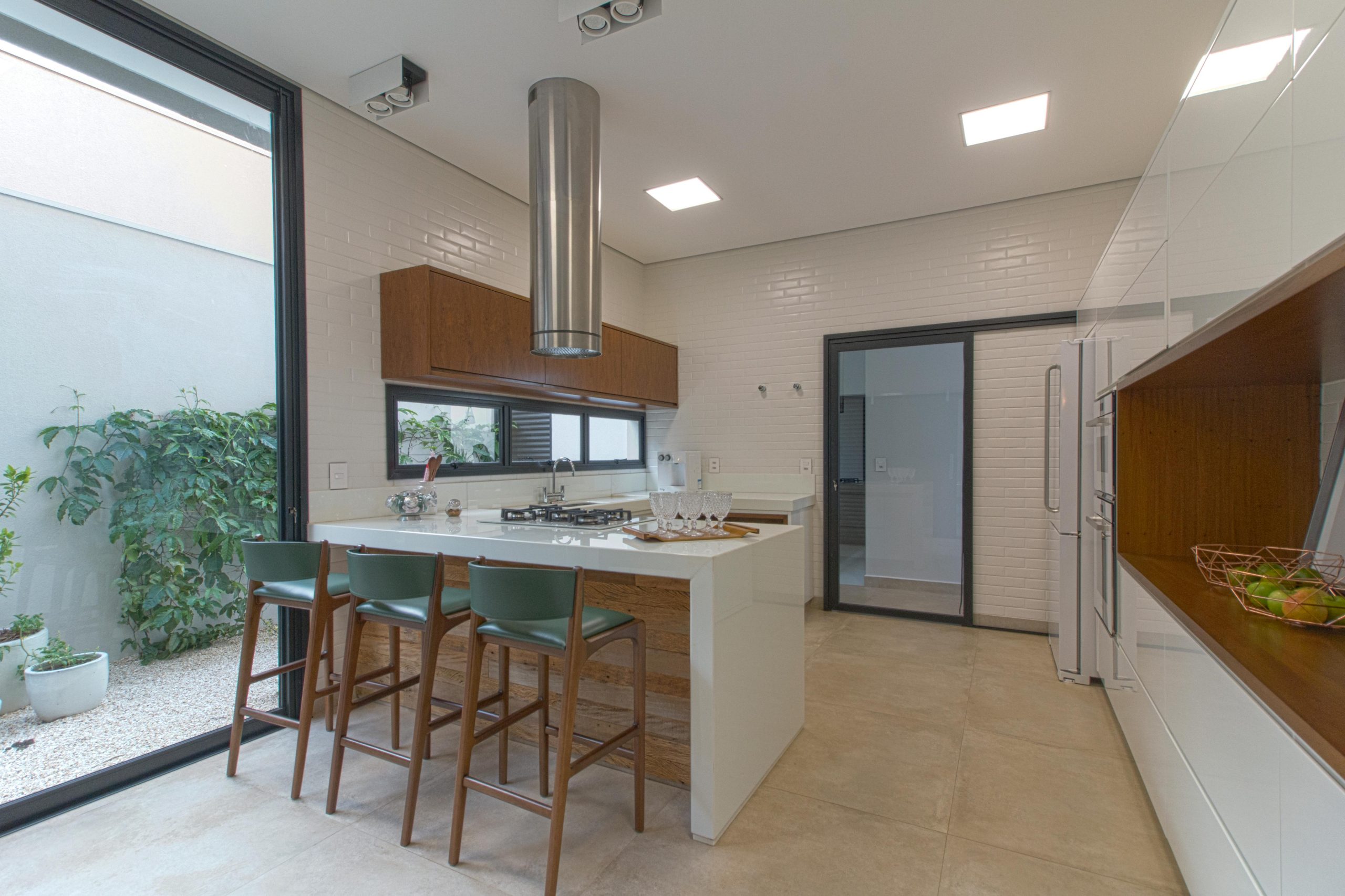 Stylish kitchen featuring white brick walls, wooden decor, and bar stools.