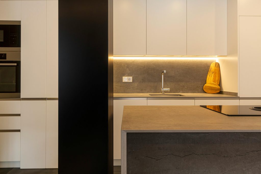 A stylish kitchen featuring modern design with minimalist elements and warm lighting.